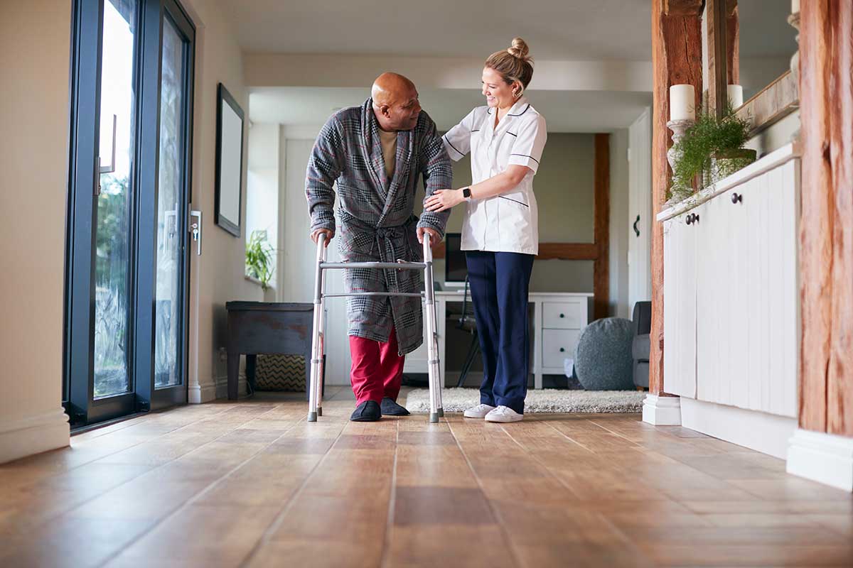 A direct care worker from Mesa AZ provides ambulation assistance to a senior gentleman in Tuscon AZ.